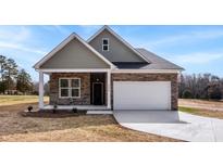 Charming single-Gathering home featuring stone accents, a two-car garage and a well-manicured front yard at 4085 Miller Rd, Salisbury, NC 28147