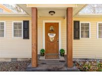 Inviting front entryway features a stained door, wooden pillars, and a cozy welcome mat at 4919 Rehobeth Rd, Waxhaw, NC 28173