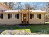 Charming home featuring a cozy front porch with wooden columns and black shutters on a sunny day at 4919 Rehobeth Rd, Waxhaw, NC 28173