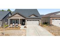 Charming single-story home featuring a covered porch, two-car garage, and well-maintained landscaping at 7312 Doak Ct, Gastonia, NC 28056