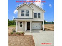 Charming two-story home featuring a one-car garage, neat landscaping, and neutral siding under a sunny sky at 807 Jost St, Statesville, NC 28677