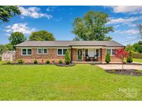 Charming brick ranch with well-manicured front yard and inviting front porch at 905 Blalock Dr, Kings Mountain, NC 28086