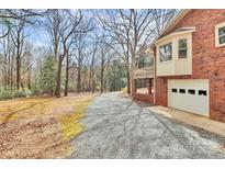 Gravel driveway leads to a brick home, blending with the surrounding trees at 1069 W Rebound Rd, Van Wyck, SC 29720