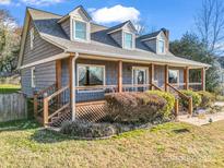 Charming home featuring a cozy front porch, wood accents, and a neatly landscaped yard on a sunny day at 111 Oakwood Dr, Kings Mountain, NC 28086