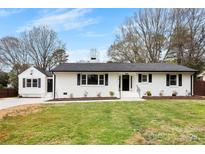 Charming single-story home with fresh white paint, black shutters, manicured lawn and complementing detached garage at 1121 S Edgemont Ave, Gastonia, NC 28054