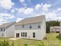 View of the home's rear exterior, showcasing the siding, windows, and a spacious backyard at 122 Asmodean Ln, Troutman, NC 28166