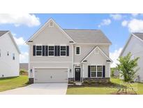Charming two-story home featuring neutral siding, black shutters, and well-maintained landscaping at 122 Asmodean Ln, Troutman, NC 28166
