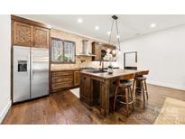 Kitchen island with barstool seating and stainless steel appliances at 13124 Lemmond Dr, Matthews, NC 28105