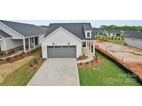 Charming single-Gathering home with a grey garage door, manicured lawn, and inviting curb appeal at 1529 Pebble Shore Ln # 164, Belmont, NC 28012