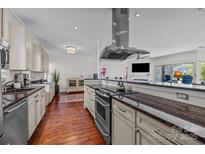 Bright kitchen features stainless steel range hood, granite countertops, wooden floors and views into the living room at 224 N Poplar St # 9, Charlotte, NC 28202