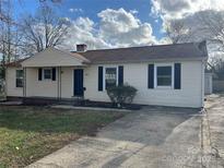 Charming single-story home featuring a well-maintained lawn, black shutters, and a paved driveway at 2908 Bellaire Dr, Charlotte, NC 28216