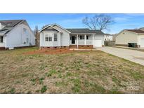 Charming single Gathering home featuring a cozy front porch and manicured lawn at 3632 Farm Lake Sw Dr, Concord, NC 28027