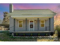 Charming home featuring a cozy front porch with decorative iron railings and landscaped garden, perfect for relaxing evenings at 520 Rogers St, Albemarle, NC 28001