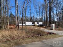 Exterior view of a white single-story home with black shutters surrounded by trees at 635 Acre Ct, York, SC 29745
