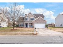 Charming two-story home with a brick and siding exterior, blue shutters, and well-manicured landscaping at 696 Yvonne Sw Dr, Concord, NC 28027