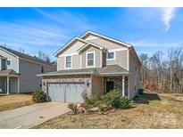 Charming two-story home with a brick-accented garage and well-maintained landscaping at 7512 Spring Spruce Ln, Charlotte, NC 28227