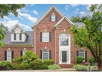 Charming brick two-story home featuring black shutters and a lush, landscaped front yard at 9423 Belmont Ln, Marvin, NC 28173