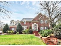 Elegant two-story brick home with manicured lawn and charming architectural details at 9800 Deer Brook Ln, Charlotte, NC 28210