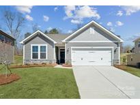 Charming home featuring a two-car garage, stone accents, manicured lawn, and beautiful curb appeal at 9932 Manor Vista Trl, Kannapolis, NC 28027