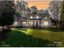 Charming two-story home featuring a welcoming front porch and lush, green lawn at dusk at 107 Doris Ct, Lincolnton, NC 28092