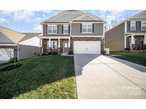 Charming two-story home with stone accents, a well-manicured lawn, and an attached two-car garage at 176 Cherry Birch St, Mooresville, NC 28117