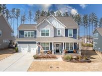 Charming two-story home with a welcoming front porch, two-car garage, and well-manicured landscaping at 2024 Linn Cv, Waxhaw, NC 28173