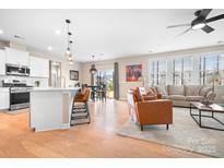 Inviting living space featuring a modern kitchen, a cozy sitting area, and stylish hardwood floors at 2024 Linn Cv, Waxhaw, NC 28173