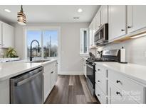 Bright kitchen featuring stainless steel appliances, white cabinets, and hardwood floors at 2132 Electric Ln, Charlotte, NC 28205
