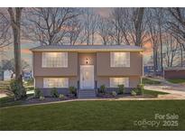 Charming split-level home featuring a well-manicured lawn, complemented by the house's warm exterior and inviting front entrance at 4836 Cheviot Rd, Charlotte, NC 28269