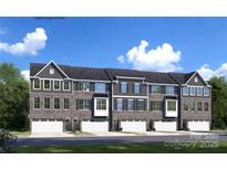 Stylish townhome exterior featuring stone accents, attached garages, and attractive architectural details at 5040 Grain Orchard Rd # 3024C, Indian Trail, NC 28079