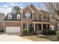 Charming brick home with a well-manicured lawn and inviting front porch at 5672 Wrenfield Ct, Charlotte, NC 28277