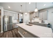 Stylish kitchen with stainless steel appliances, gray cabinets, and a large center island with pendant lighting at 7133 Yardley St, Gastonia, NC 28056