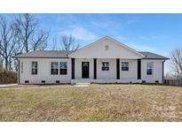 Charming brick home with a welcoming front porch and well-manicured lawn under a bright sky at 7215 Kilcullen Dr, Charlotte, NC 28270