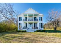 Charming two-story home with a large front yard and a welcoming front porch with blue ceiling at 881 Saluda Rd, Chester, SC 29706