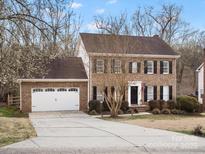 Charming brick home featuring a manicured front lawn, attached two-car garage, and classic colonial architecture at 14723 Sapphire Ln, Pineville, NC 28134