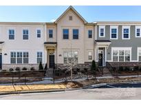 Charming townhome featuring a landscaped front yard and classic architectural details at 15140 Rocky Bluff Loop, Davidson, NC 28036