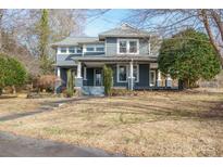 Charming blue two-story home featuring a cozy front porch and mature trees at 1740 12Th Street Nw Dr, Hickory, NC 28601