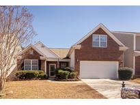 Charming brick home featuring a well-manicured lawn, an attached garage, and an inviting front entrance at 2011 Savannah Hills Dr, Matthews, NC 28105