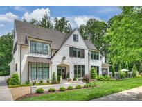 Charming white brick home with black-framed windows and professionally landscaped front yard at 2509 Montrose Ct, Charlotte, NC 28207