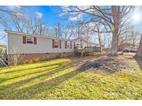 Charming home featuring a large yard, deck, and mature trees, perfect for outdoor entertaining at 334 Hillcrest Dr, Mooresville, NC 28115