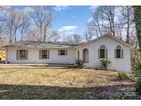 Charming, single-story brick home boasts a well-manicured lawn and inviting arched entryway with neutral trim at 604 White Oak Ct, Gastonia, NC 28056