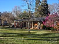 Charming brick ranch-style home with a sprawling lawn and a covered front porch, perfect for enjoying the outdoors at 624 Patricia Ave, Harrisburg, NC 28075
