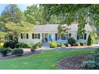 Charming single-story home with a well-manicured lawn and lush landscaping, offering great curb appeal at 6818 Ronda Ave, Charlotte, NC 28211