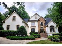 Elegant two-story home featuring a stone facade, arched windows, and mature landscaping at 1025 Seminole Dr, Waxhaw, NC 28173