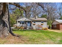 Charming gray brick home featuring a well-maintained lawn, blue door and inviting curb appeal at 2727 Hilliard Dr, Charlotte, NC 28205