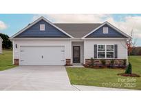 Charming one-story home featuring blue and white siding, an attached two-car garage, and a well-manicured lawn at 3354 Burberry Dr, Gastonia, NC 28052