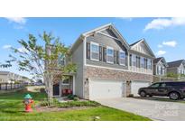 Charming two-story home featuring stone accents, a two-car garage, and a well-manicured front yard at 3878 Fairlady Ln, Fort Mill, SC 29707