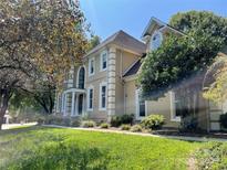 Elegant two-story home featuring a stucco facade, white trim, arched windows and lush green lawn and mature trees at 4825 1St Street Nw Ct, Hickory, NC 28601