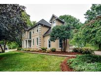 Side view of a two-story home with manicured lawn and mature landscaping at 4825 1St Street Nw Ct, Hickory, NC 28601