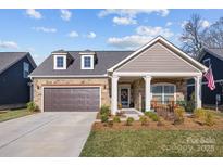 Charming home featuring a two-car garage, manicured lawn, and inviting front porch area at 6015 Pleasant Run Dr, Matthews, NC 28104